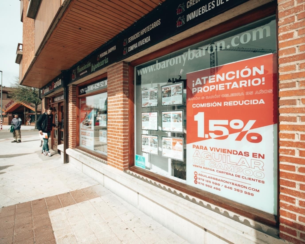 En la imagen, el cartel informativo de la promoción en la fachada de la Inmobiliaria Aguilarense Barón & Barón.