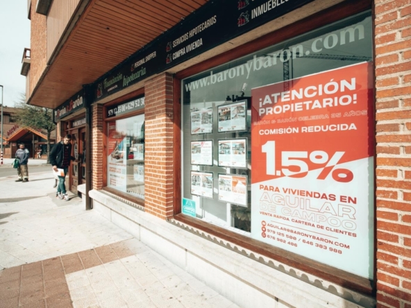 En la imagen, el cartel informativo de la promoción en la fachada de la Inmobiliaria Aguilarense Barón & Barón.
